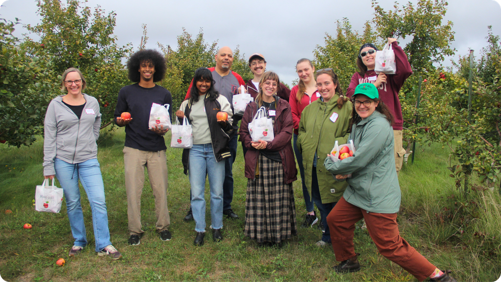 Rivers Co-op Markets produce teams in the Whistling Well Farm apple fields, showing off freshly picked Honeycrisp apples.